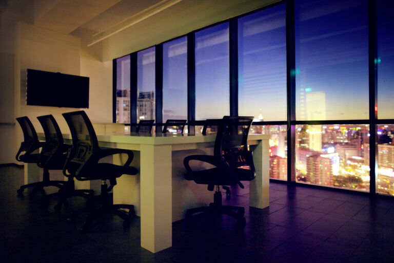 View of office conference room at night with cityscape